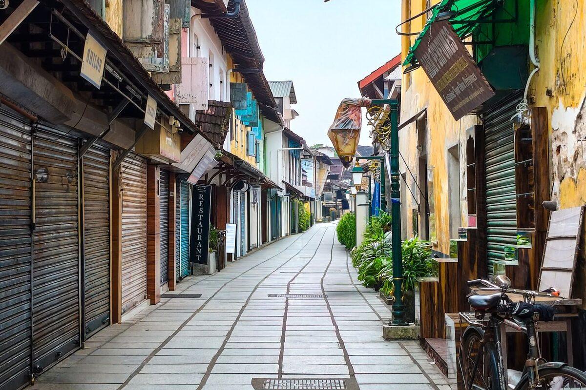 Colourful colonial-era heritage street in Fort Kochi with old shopfronts and a bicycle