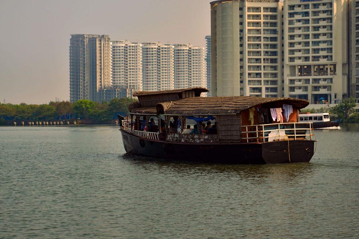 Boat on the water with Kochi's modern high-rise skyline along the waterfront
