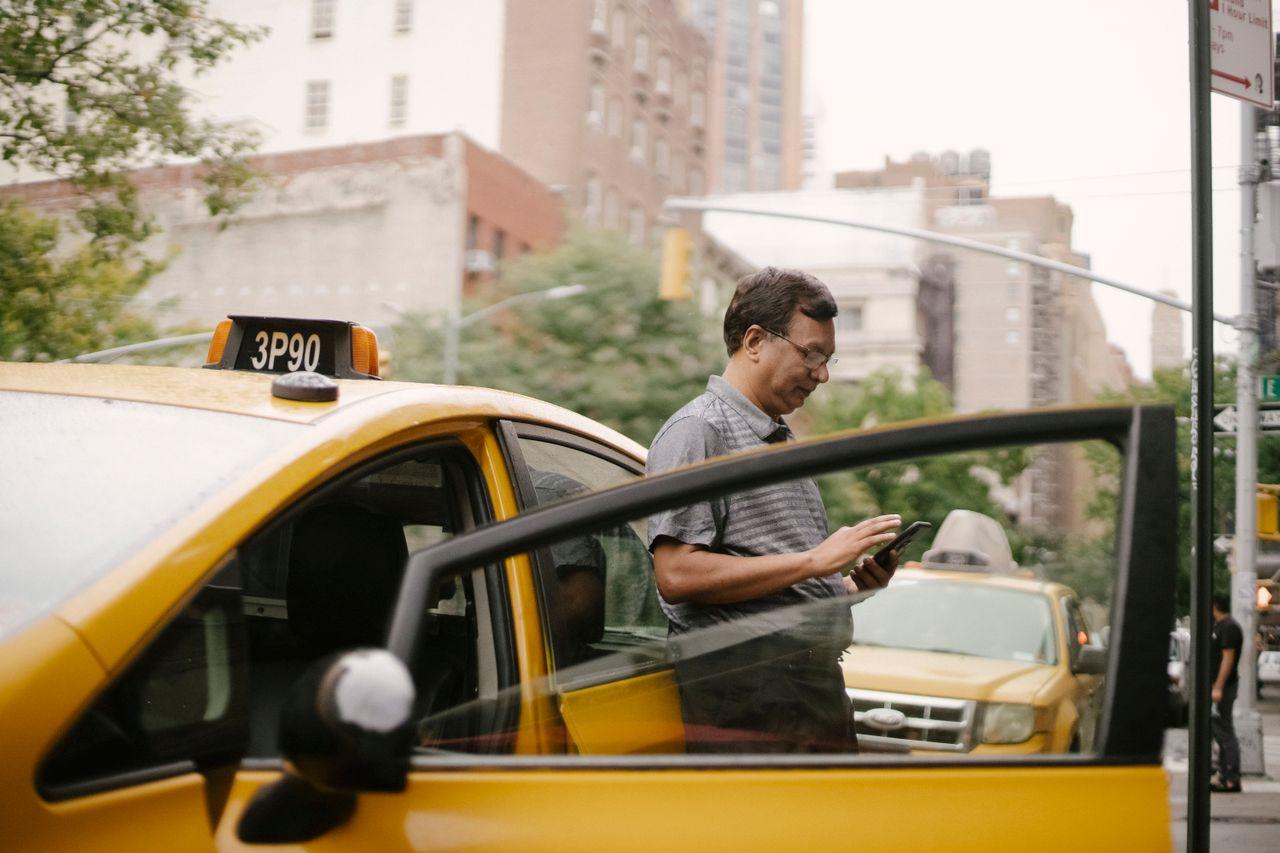 taxi driver smartphone app city street — Kera Cabs — 55% of Bookings Moved Off the Phone and Into the App delivered by Acube Innovations (ERPNext, AI & software, India)