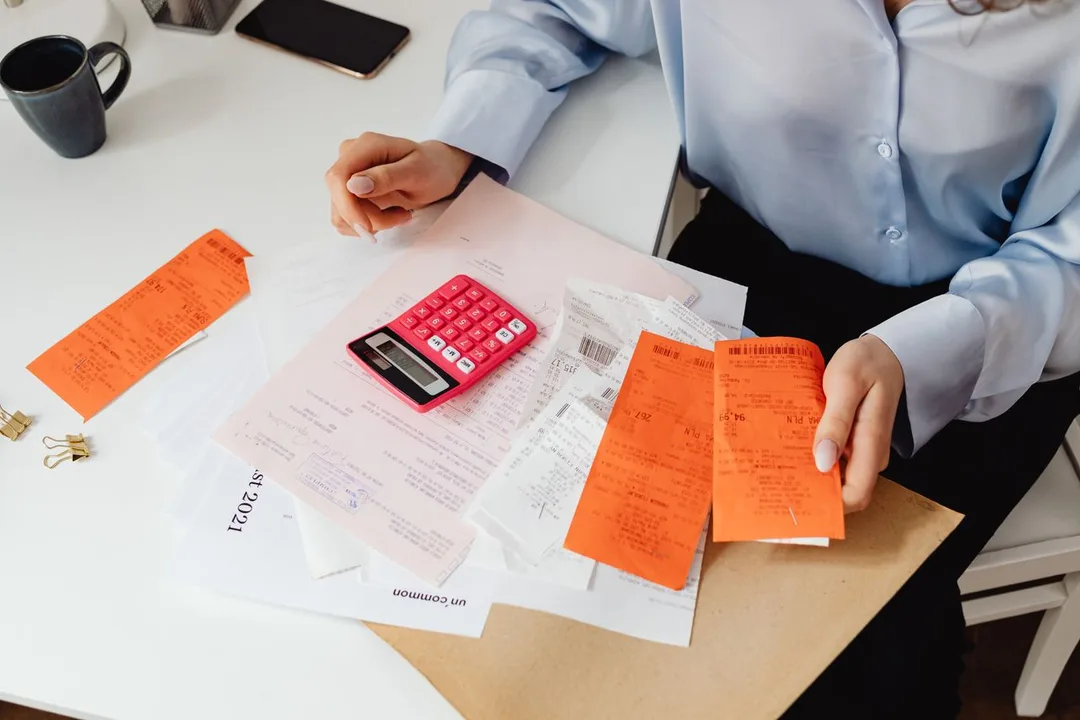 Accountant working through invoices with a calculator
