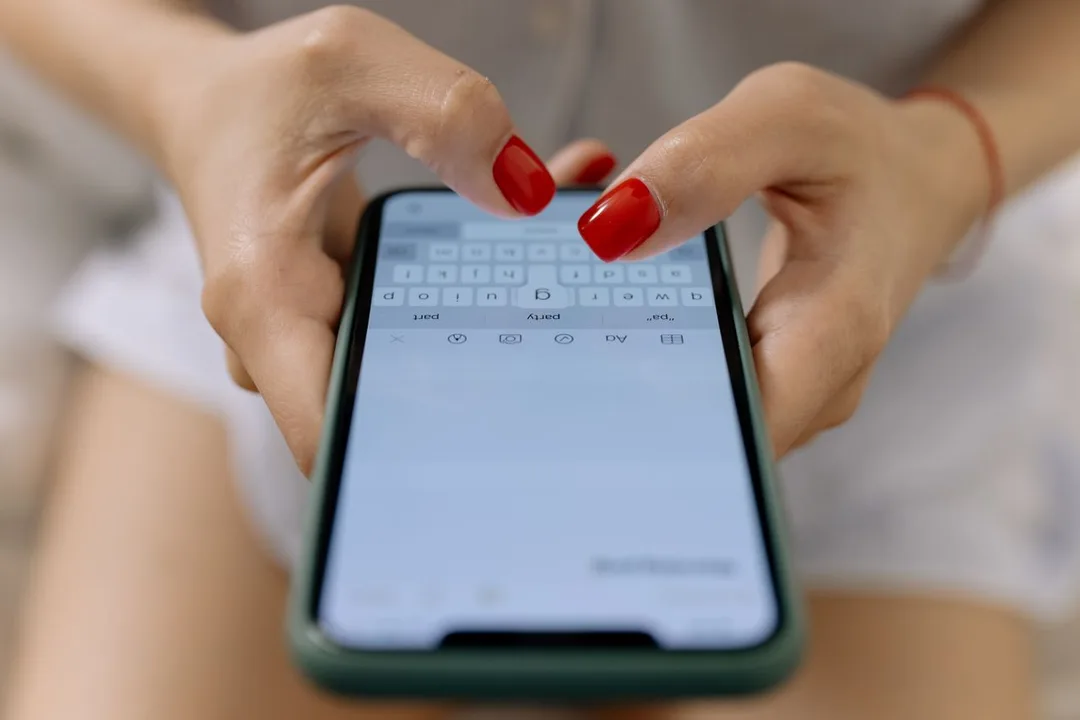 Hands typing a message on a smartphone