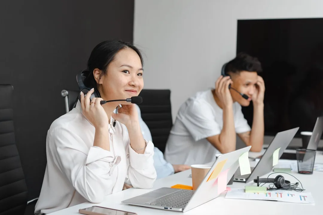 Call-centre agents wearing headsets at their laptops