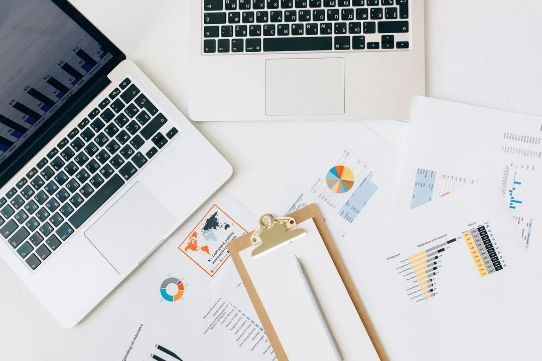 Laptop and printed charts laid out on a marketing desk
