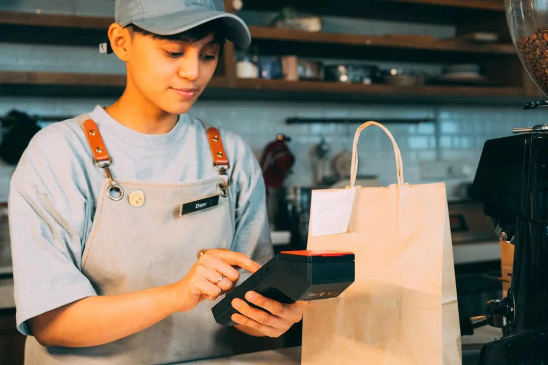 Shop assistant billing a purchase on a handheld device