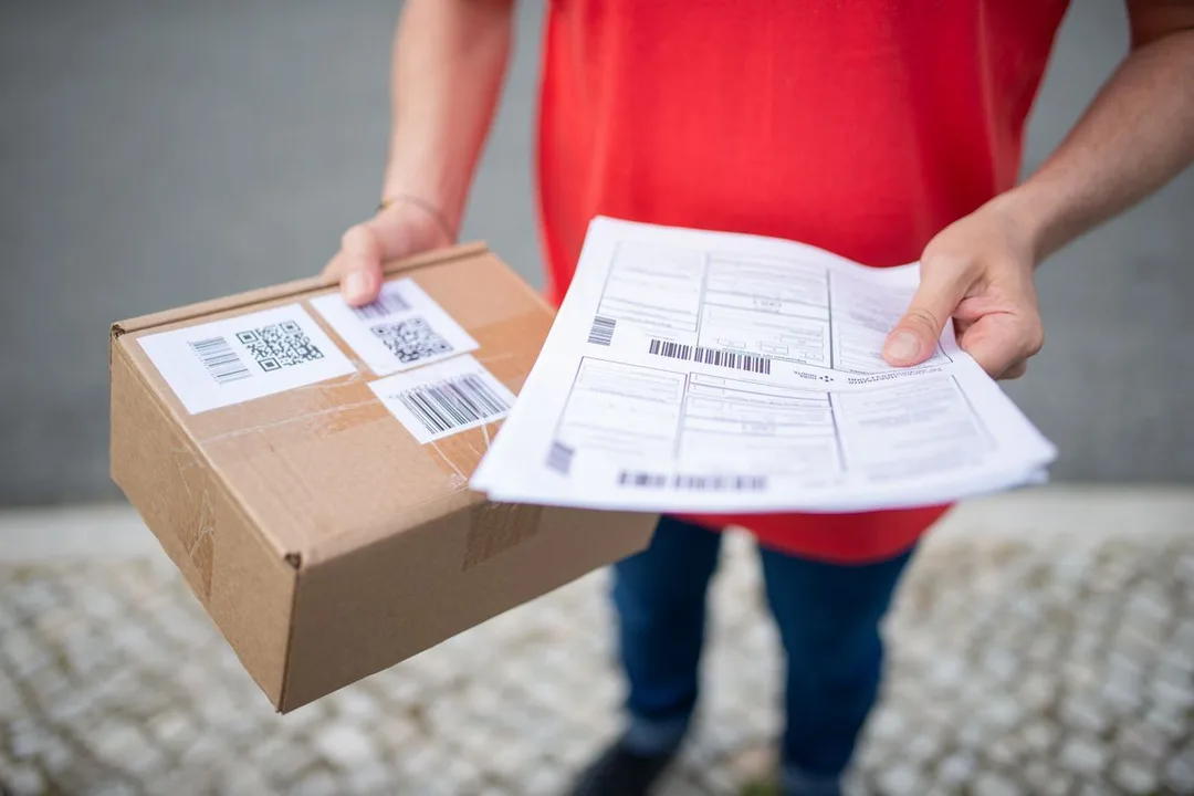 Carton carrying printed tracking labels beside its dispatch paperwork