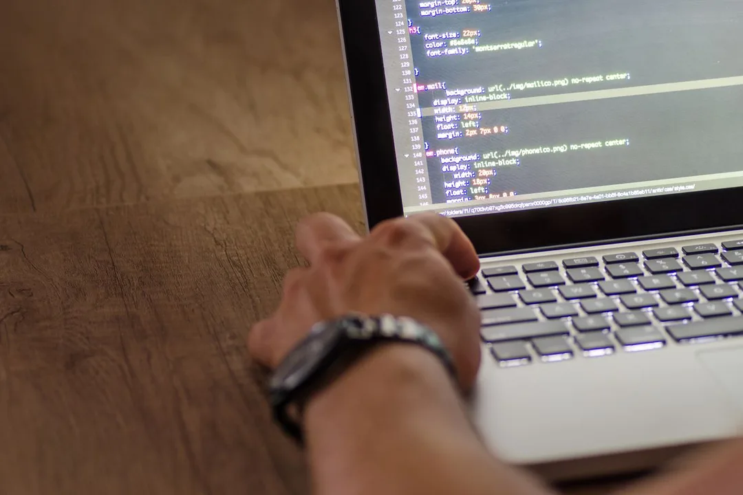 Developer writing application code on a laptop
