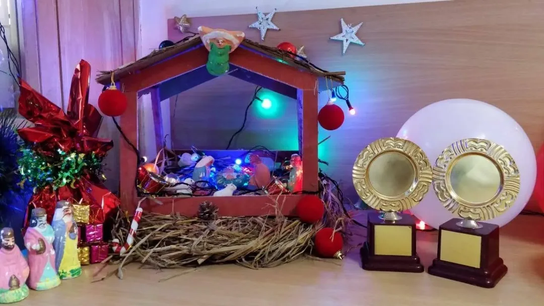 A Christmas crib with lights and two trophies at the Acube office