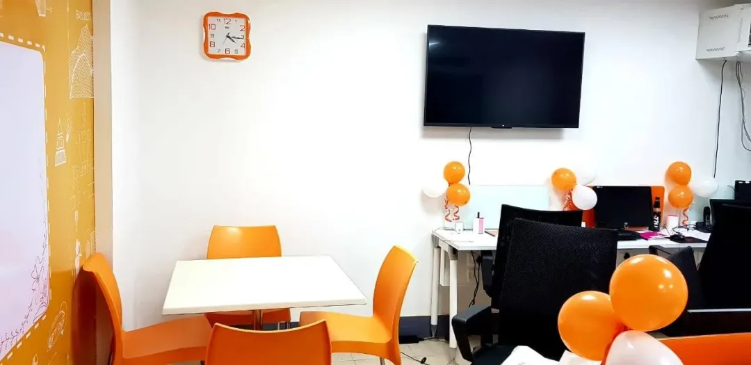The office's meeting area with orange chairs and balloons